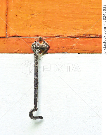 Stained metal shutter hook installed on brown wood Stained metal shutter hook installed on brown wood 38243032