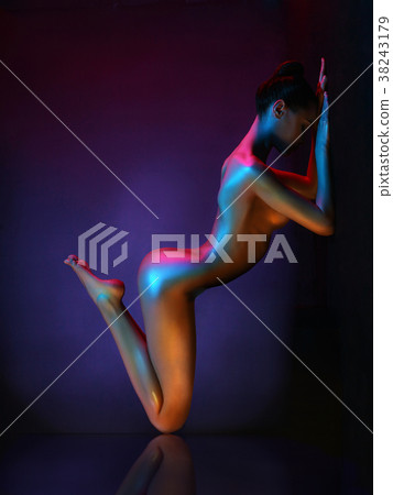 Elegant nude model in the light colored spotlights Elegant nude model in the light colored spotlights 38243179