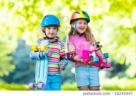 Children riding skateboard in summer park Children riding skateboard in summer park 38243847