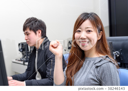 University students teaching each other in front of a computer University students teaching each other in front of a computer 38246143