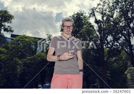 Young man messaging in a city park 38247001