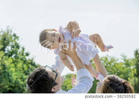 Three-person family playing in the park 38250582