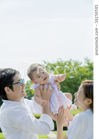 Three-person family playing in the park 38250585