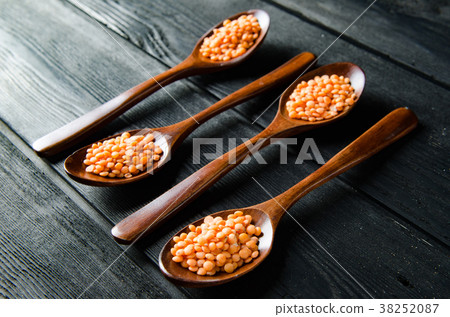 Spoons filled with uncooked lentil for soup 38252087