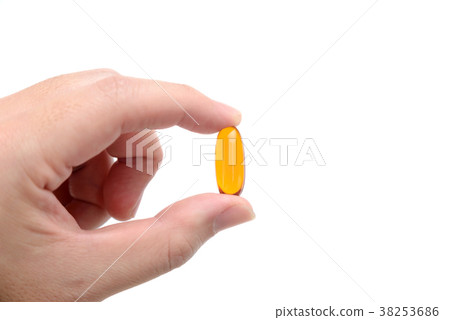 fish oil capsule in fingers on white background 38253686