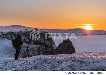 Winter landscape in sunset with young photographer 38254082
