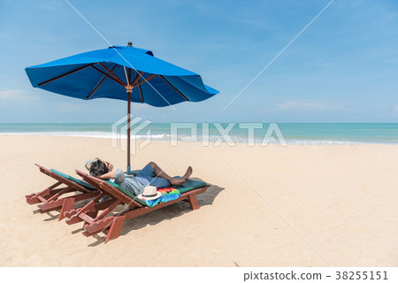 young Asain man traveler lying on beach bench young Asain man traveler lying on beach bench 38255151