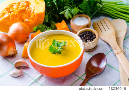 Pumpkin soup served on the table in bowl 38256046