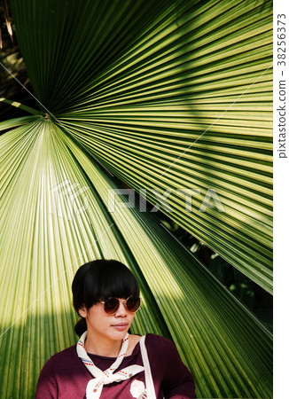Street Fashion of asian woman with big palm leaf Street Fashion of asian woman with big palm leaf 38256373