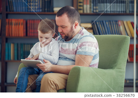 Image of happy father and young son sitting with 38256670