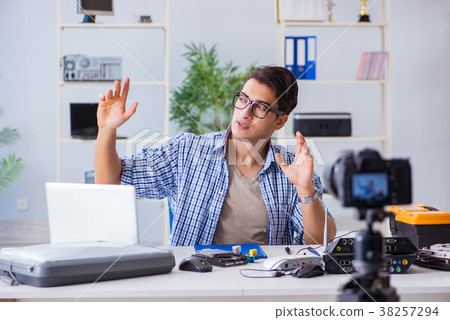 Vlogger recording computer repair on camera for 38257294