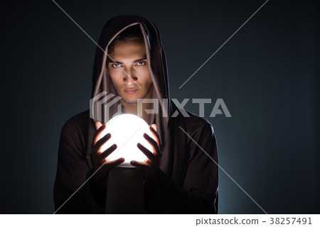 Young wizard with crystal ball in dark room Young wizard with crystal ball in dark room 38257491
