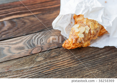 Tasty croissant in white paper bag on table. Tasty croissant in white paper bag on table. 38258369