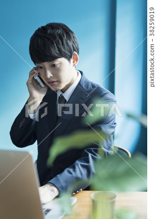 Businessman calling at shared office Businessman calling at shared office 38259019
