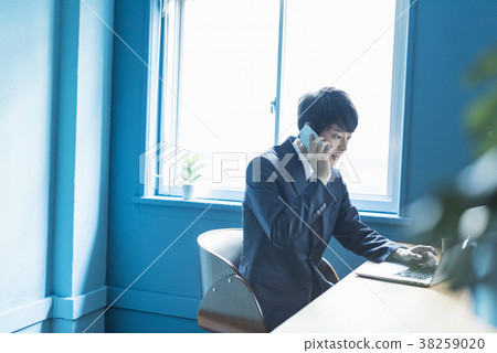 Businessman calling at shared office Businessman calling at shared office 38259020