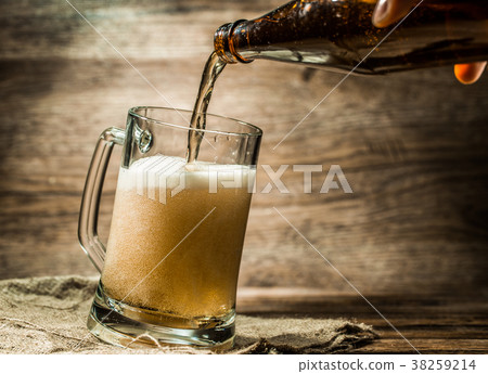 Foamy beer from bottle poured into mug Foamy beer from bottle poured into mug 38259214