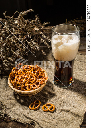 Glasse beer with wheat and basket of pretzels Glasse beer with wheat and basket of pretzels 38259333