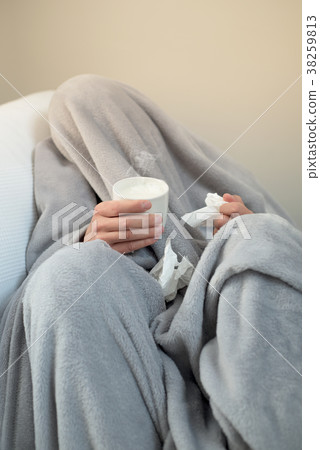 ill man warming up with a cup of hot milk 38259813