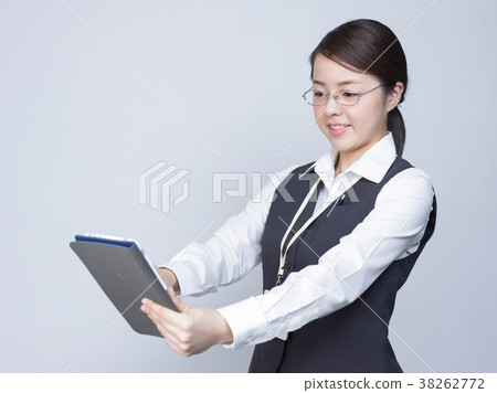 Female employee with glasses operating a tablet terminal 38262772