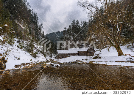 Old wooden water mill in winter with snow falling Old wooden water mill in winter with snow falling 38262973