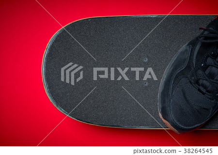 shoes and used skateboard on a red background shoes and used skateboard on a red background 38264545
