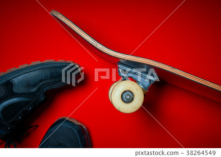 shoes and used skateboard on a red background shoes and used skateboard on a red background 38264549