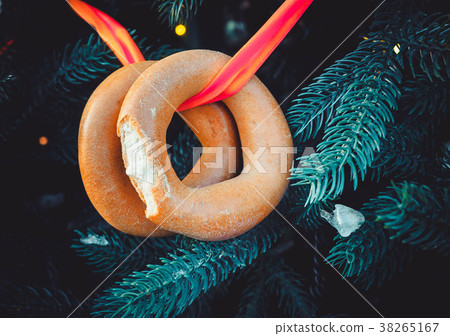 Two bitten off bagels on a ribbon hang on a Two bitten off bagels on a ribbon hang on a 38265167