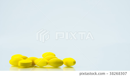 Pile of yellow tablet pills on white background  38268307