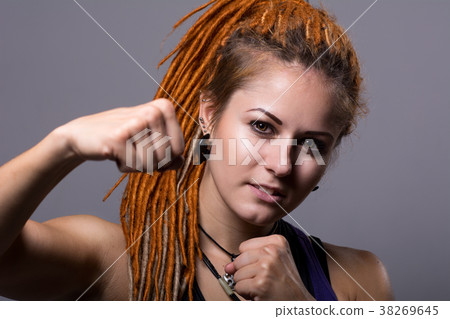 Close-up portrait young woman with dreadlocks in a fighting stan 38269645