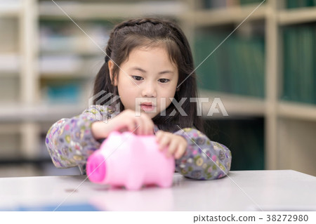 Girl playing collect money with a pink saving Pig  38272980