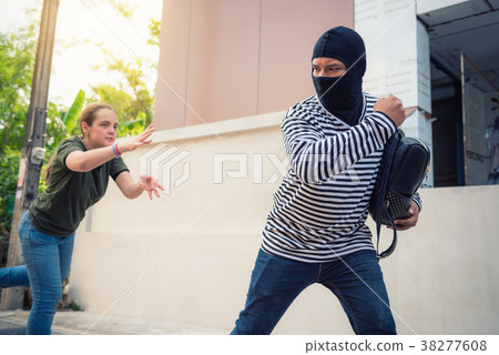 Robber snatching money and bag from women  38277608