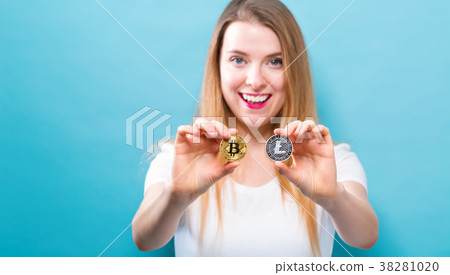 Woman holding physical bitcoin and litecoin 38281020
