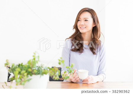 A woman who drinks tea in a room A woman who drinks tea in a room 38290362