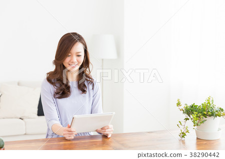 A woman watching a tablet in a room 38290442