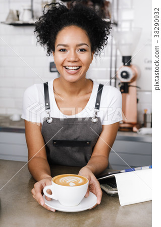 Woman barista in her coffee shop with cup of latte 38290932