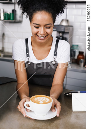 Happy waitress looking at cup of coffee Happy waitress looking at cup of coffee 38290933