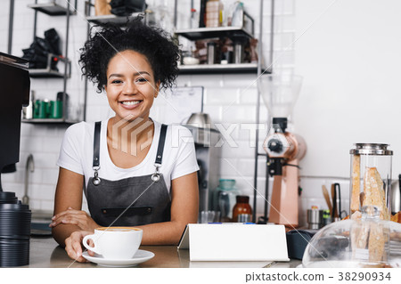 Portrait of a young curly waitress in a cafeteria Portrait of a young curly waitress in a cafeteria 38290934