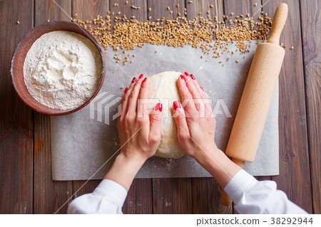 Woman's hands knead dough 38292944