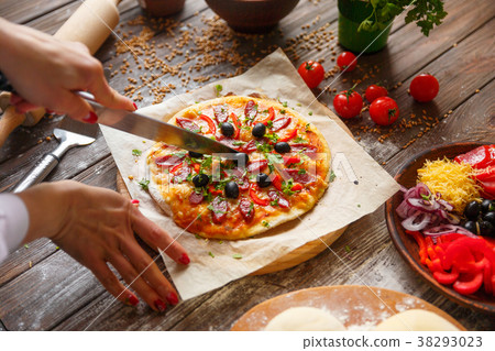Woman holding piece of pizza 38293023