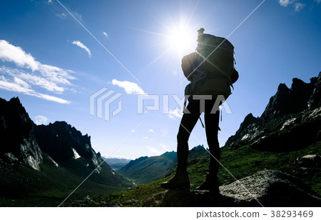 silhouette of woman hiking on sunrise mountain top 38293469