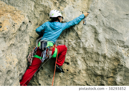 female rock climber climbing on mountain cliff 38293852