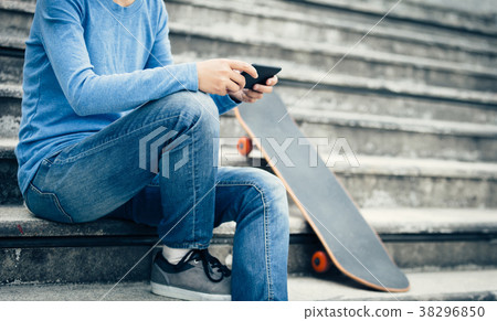 skateboarder use smartphone sit on city stairs skateboarder use smartphone sit on city stairs 38296850