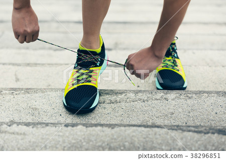 sporty woman tying shoelace on city stairs sporty woman tying shoelace on city stairs 38296851