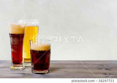 Three glasses of various beers on the wooden table 38297721