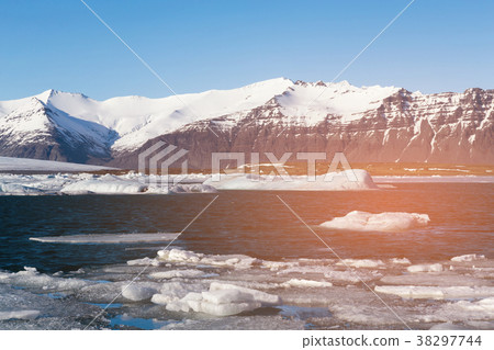 Ice on blue Jakulsarlon lagoon with volcano rock Ice on blue Jakulsarlon lagoon with volcano rock 38297744
