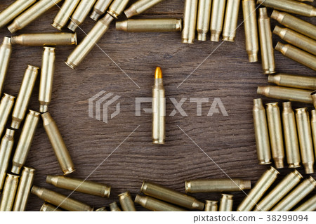 M-16 bullet on wooden table close-up. M-16 bullet on wooden table close-up. 38299094