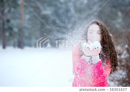 Beautiful woman blowing on the snow 38301837