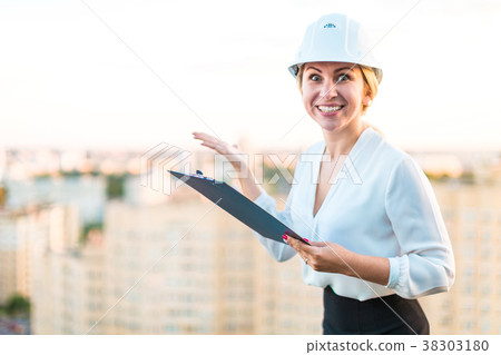 Pretty young forewoman in helmet stand on the roof Pretty young forewoman in helmet stand on the roof 38303180