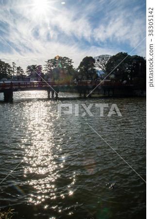 Scarlet bridge at the Odawara Castle entrance under the winter sun and flowing clouds 38305142