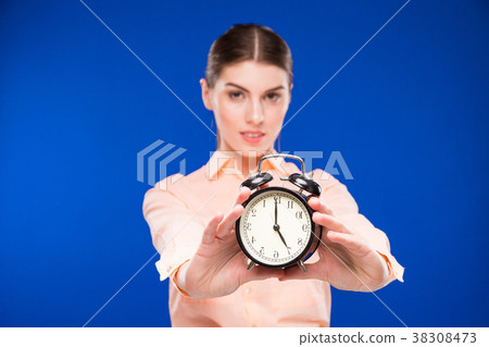 young girl with an alarm clock in focus 38308473